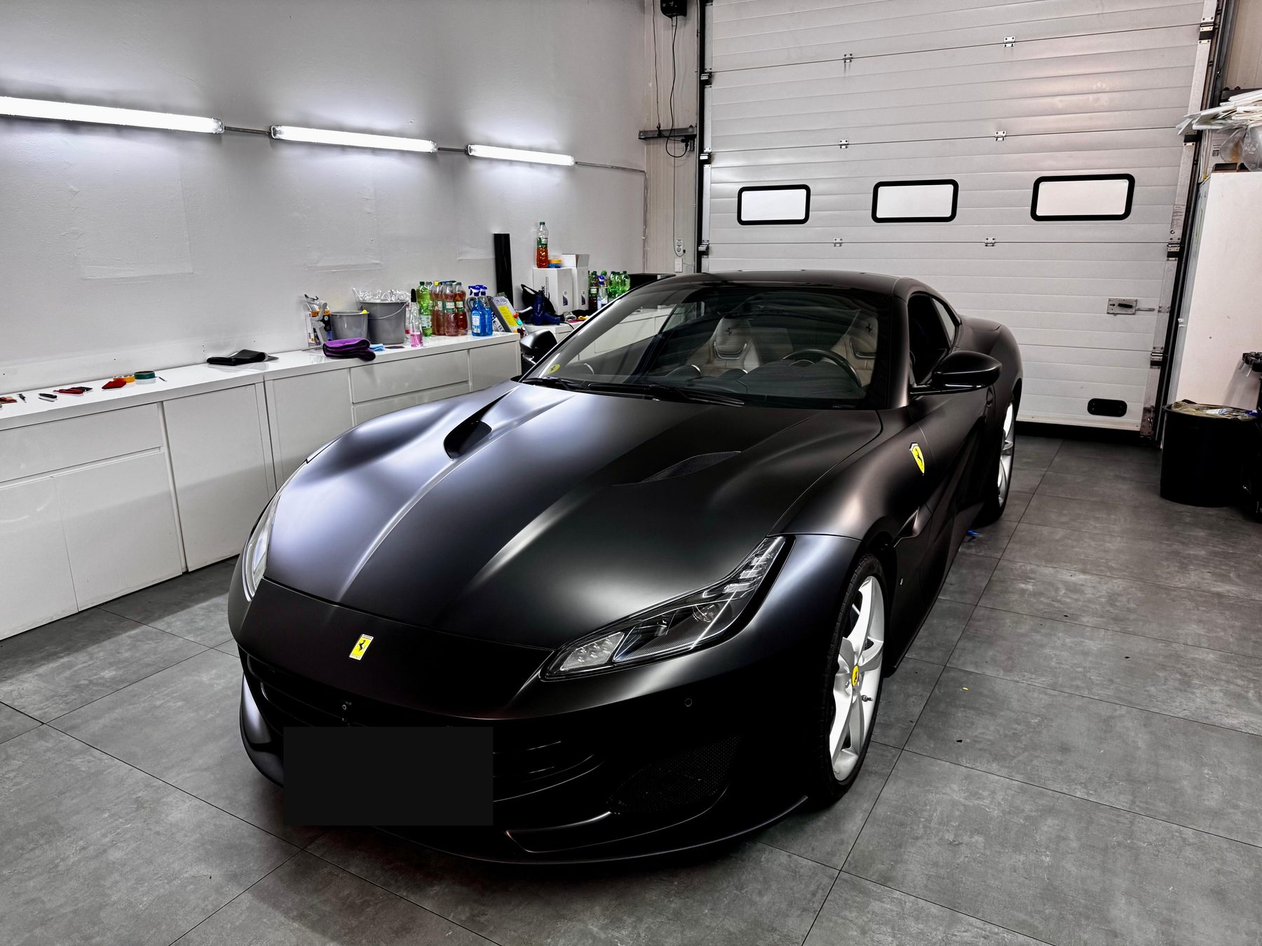 Ferrari Portofino mit Vollfolierung in Mattschwarz, Frontansicht in der Werkstatt
