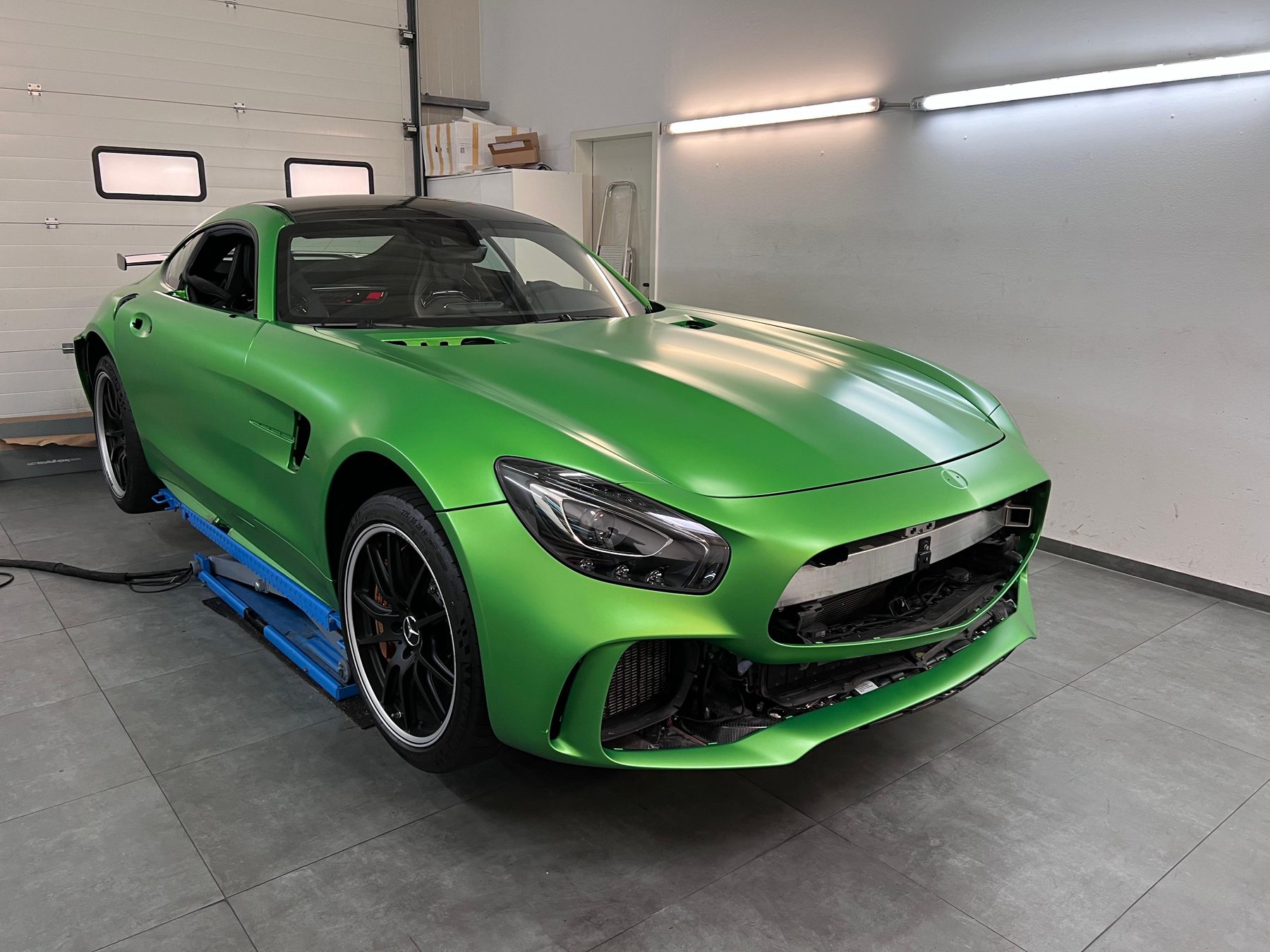 Mercedes-AMG GT während der Vollfolierung in Mattgrün, Frontstoßstange in Arbeit